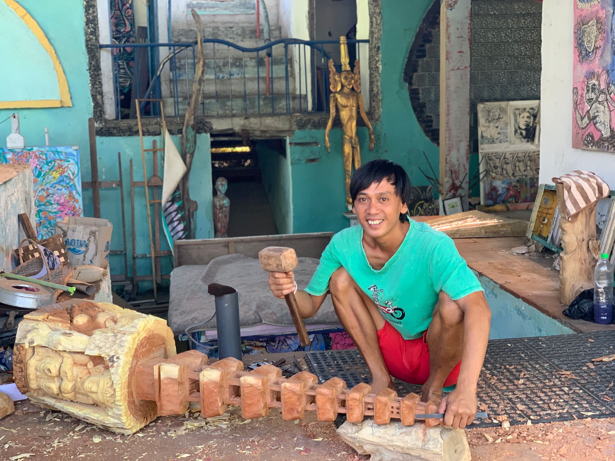 A Balinese woodcarver carefully shaping an intricate piece by hand