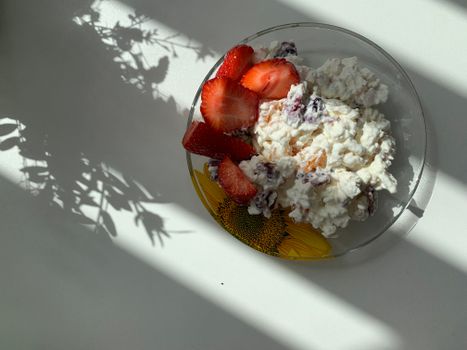 A sunlit plate of strawberries and cottage cheese perfect for breakfast.