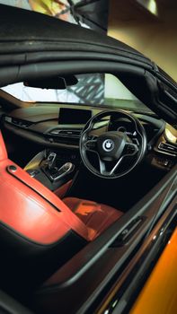 Interior view of a luxury car with red leather seats and sleek dashboard design.