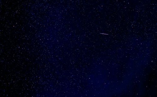Free A breathtaking view of a starry night with a shooting star in East Tawas, Michigan, USA. Stock Photo