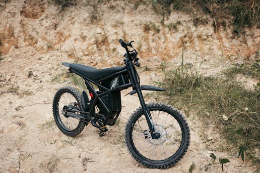A sleek off-road electric bike parked on rugged rocky terrain, perfect for adventure seekers.