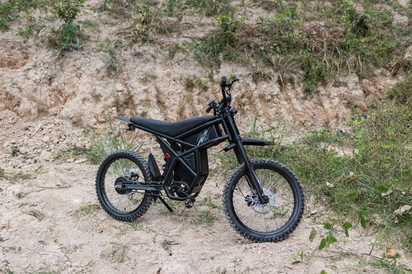 Electric dirt bike parked on a backcountry slope