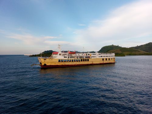 Free A large ferry boat sailing in the ocean with distant hills under a clear sky. Stock Photo