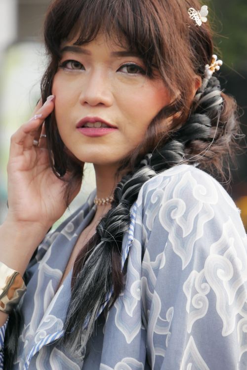 Free Stylish woman wearing a traditional patterned dress with braided hairstyle, outdoors. Stock Photo