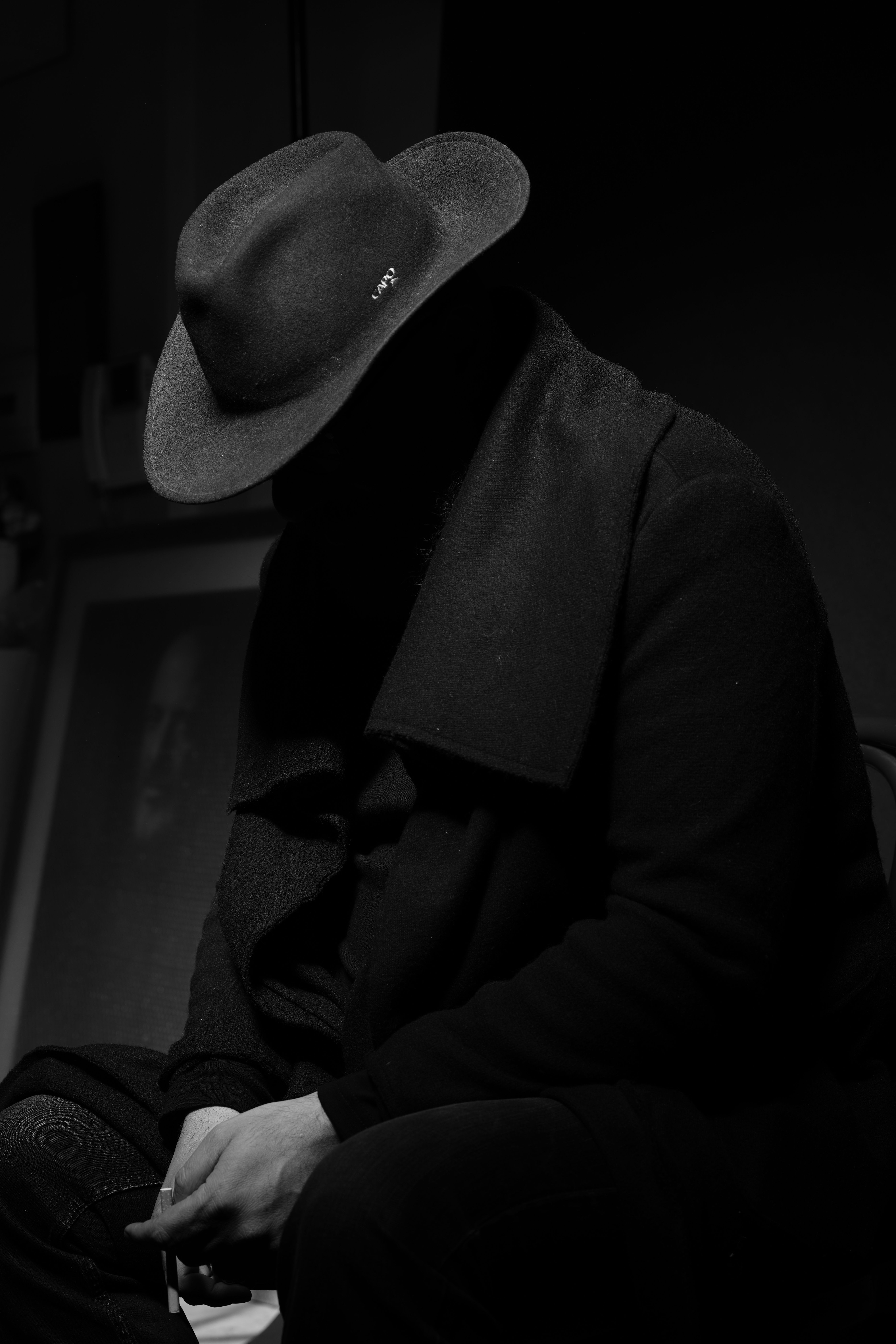 Mysterious Figure in Black Hat in Dark Studio · Free Stock Photo