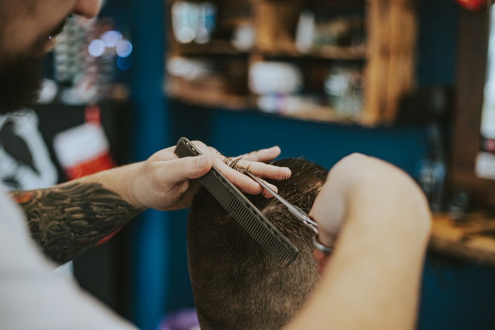 Barbero trabajando el cabello de un cliente