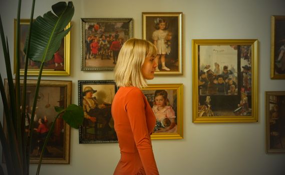 Woman in an art gallery with vintage paintings in İstanbul, Türkiye.