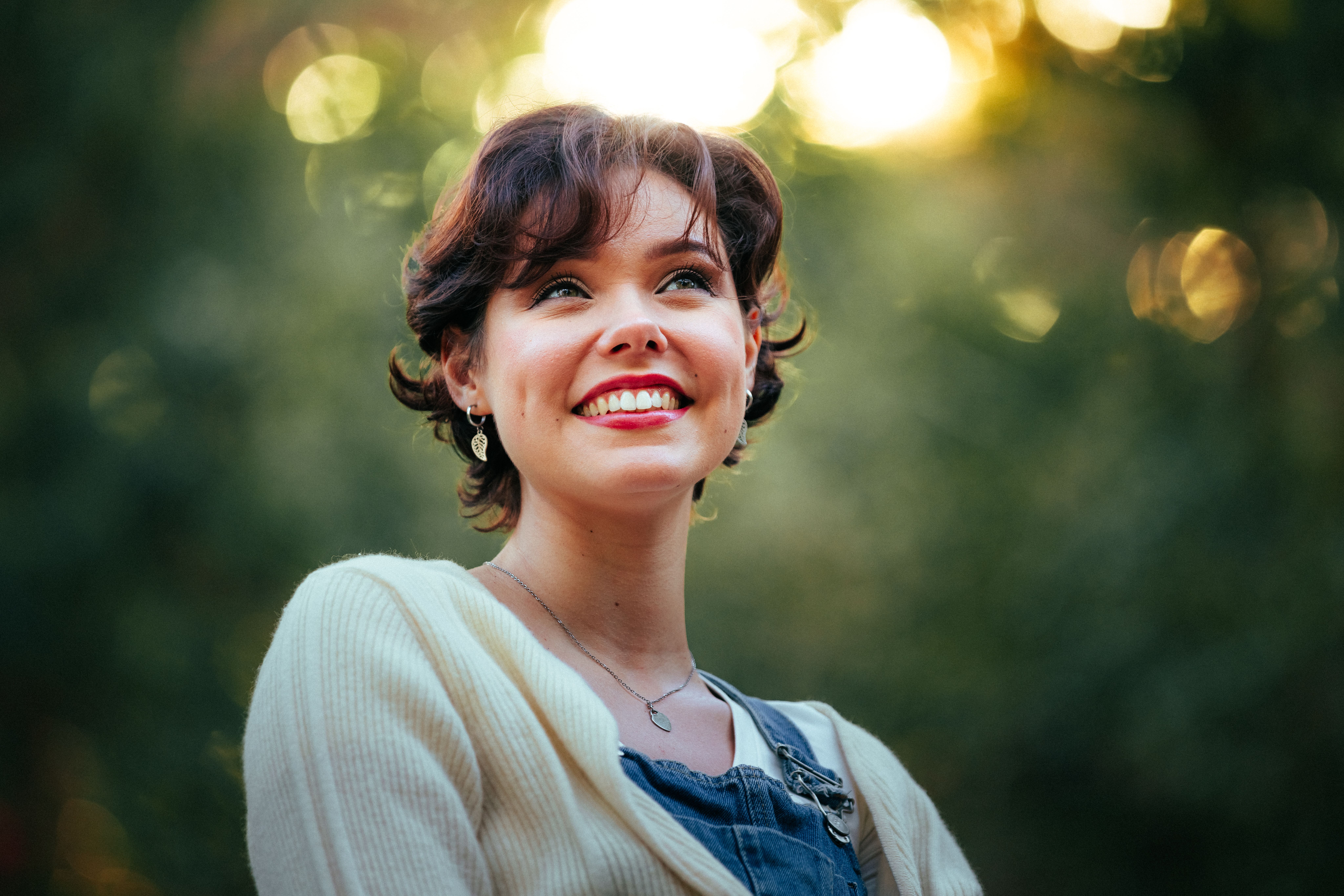 Smiling Young Woman Outdoors in Vibrant Light · Free Stock Photo