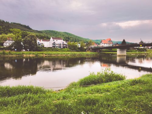 Free Charming houses line the river in Bodenwerder, Germany, surrounded by lush greenery. Stock Photo