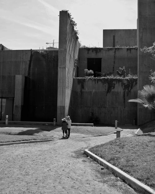 Free A couple walking by brutalist architecture in Mazatlán, Mexico. Stock Photo