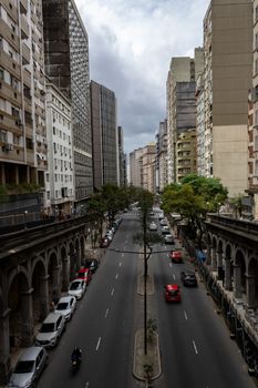High-angle view of a bustling urban street lined with tall buildings and vehicles.