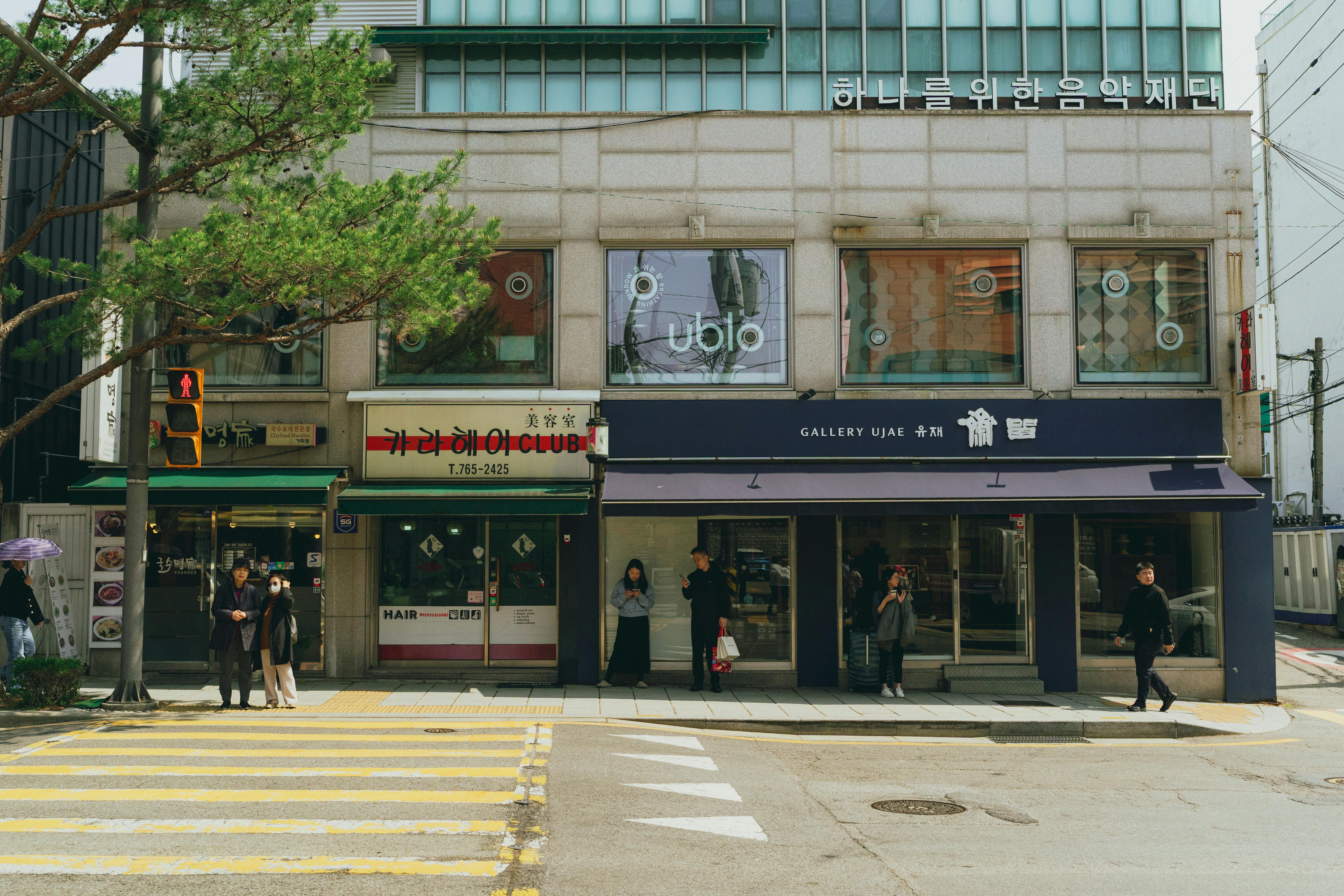 grátis Uma animada cena de rua no centro de Seul, exibindo a arquitetura coreana e a vida cotidiana da cidade. Foto profissional