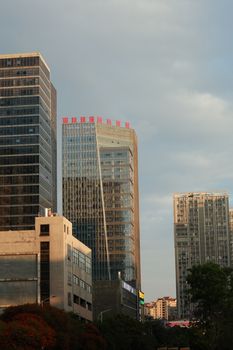 Modern skyscrapers in a bustling city captured during sunset, highlighting urban architecture.
