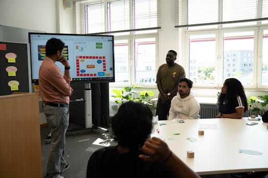 Group of diverse young professionals collaborating with a presentation in a bright office.