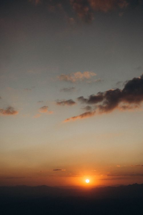 Free Capture the tranquility of a stunning sunset with dramatic clouds. Stock Photo
