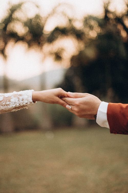 Free Close-up of a couple holding hands in a romantic outdoor setting. Stock Photo