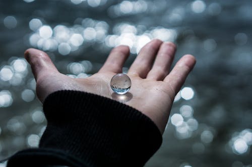 Free A Person with a Marble on It's Palm Stock Photo