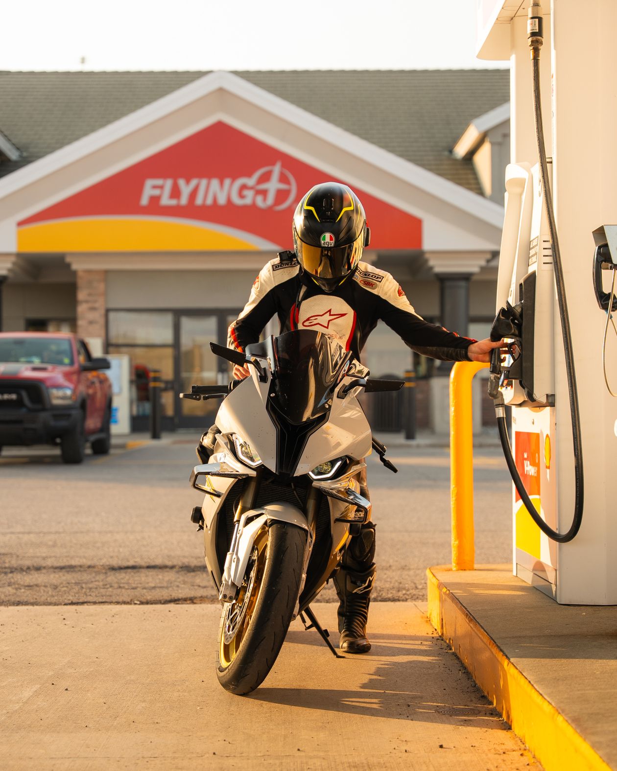 Motorcyclist refueling at a gas station during the day
