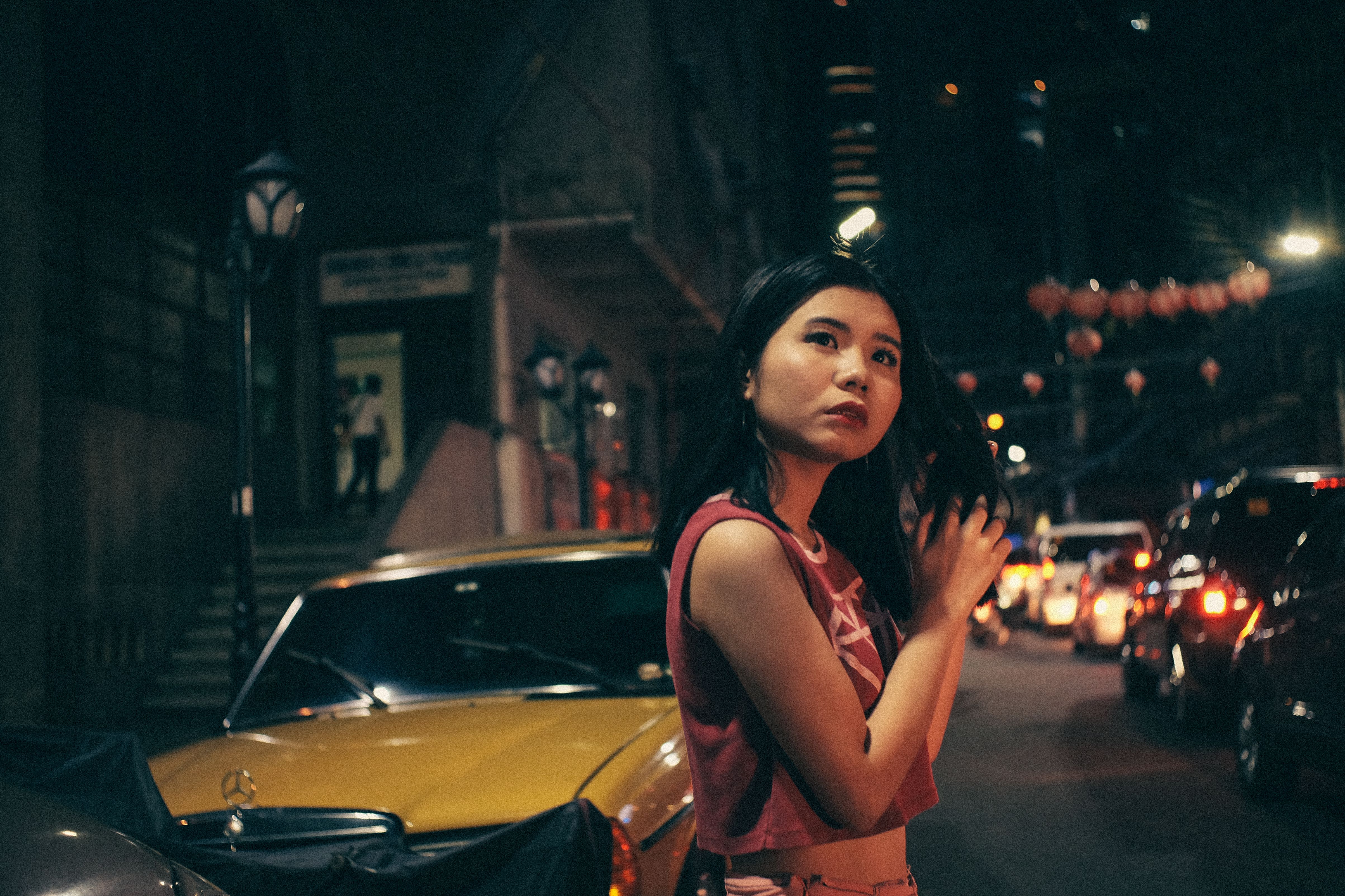 A woman walking briskly at night, her silhouette illuminated by streetlights, embodying the quiet urgency of the nocturnal stride.
