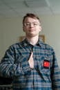 Young Man with Hand on Heart in Checkered Shirt