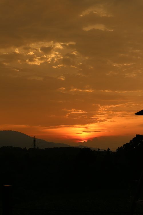 Free Captivating sunset with orange hues and clouds over mountains. Stock Photo