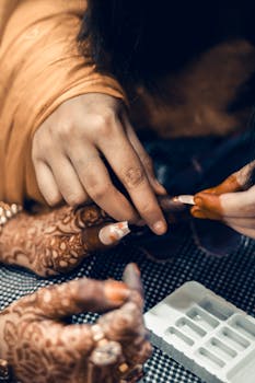 Close-up of henna and nail art application during a traditional Indian wedding ceremony.