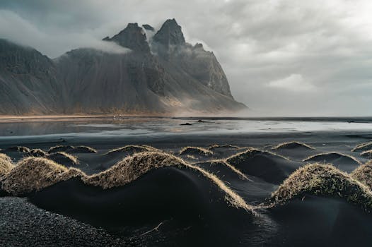Scenic view of Vestrahorn Mountain and the unique black sand dunes in Iceland, capturing a moody landscape.