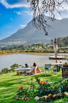 Couple relaxing by a lake with stunning mountain and garden view.