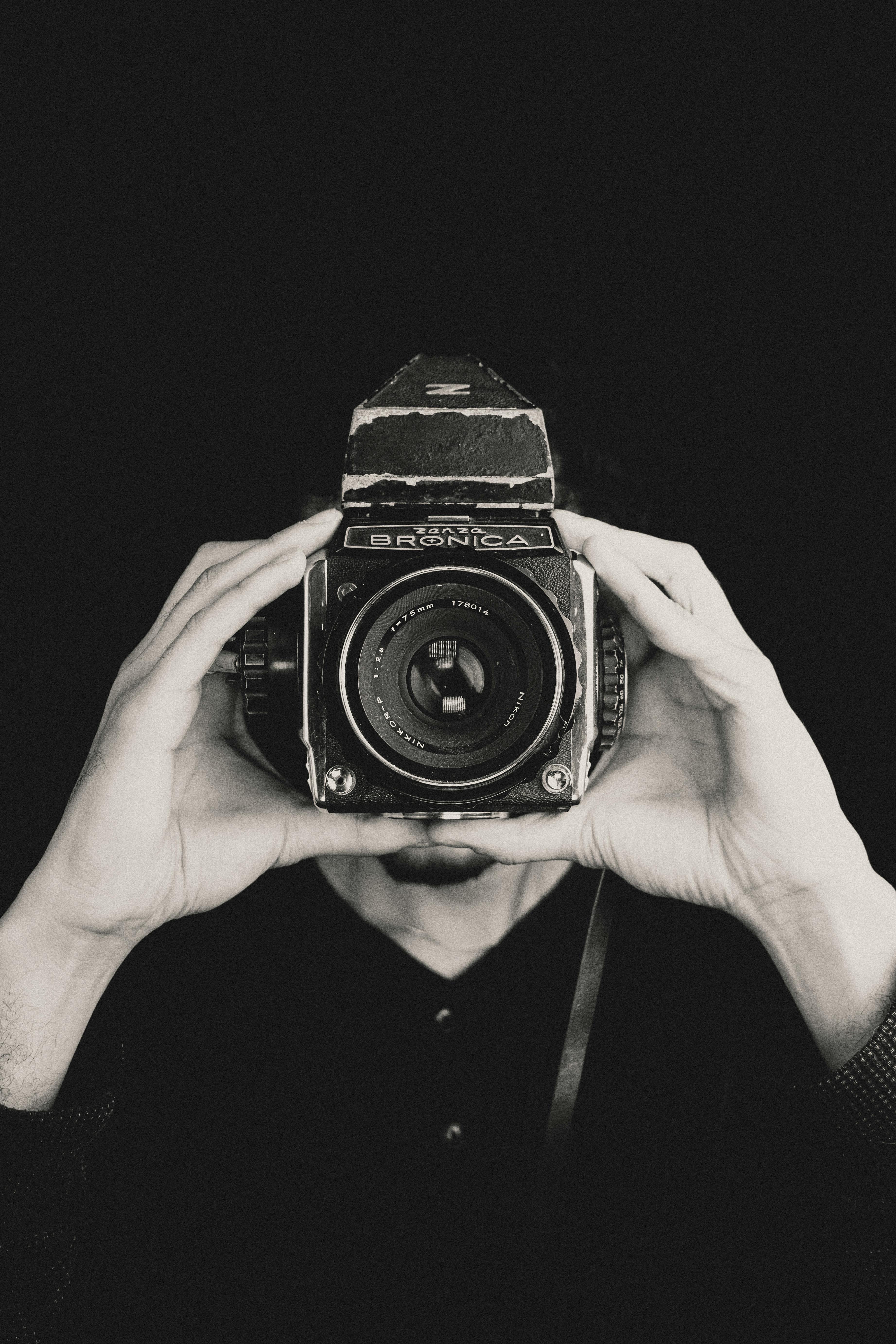 A person holds a classic vintage camera, capturing a timeless moment.