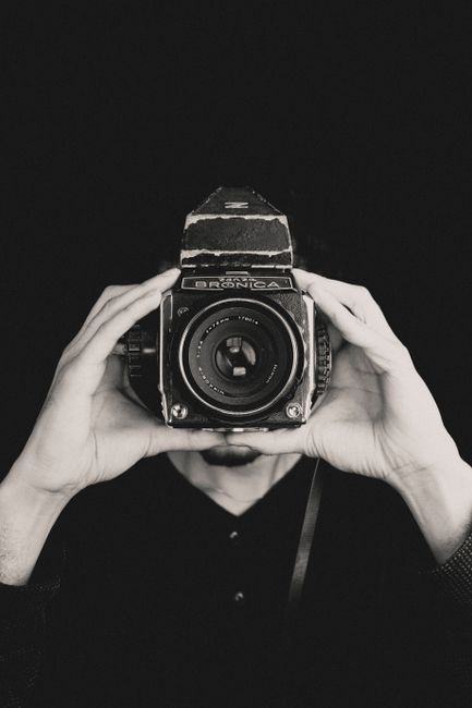 A person holds a classic vintage camera, capturing a timeless moment.