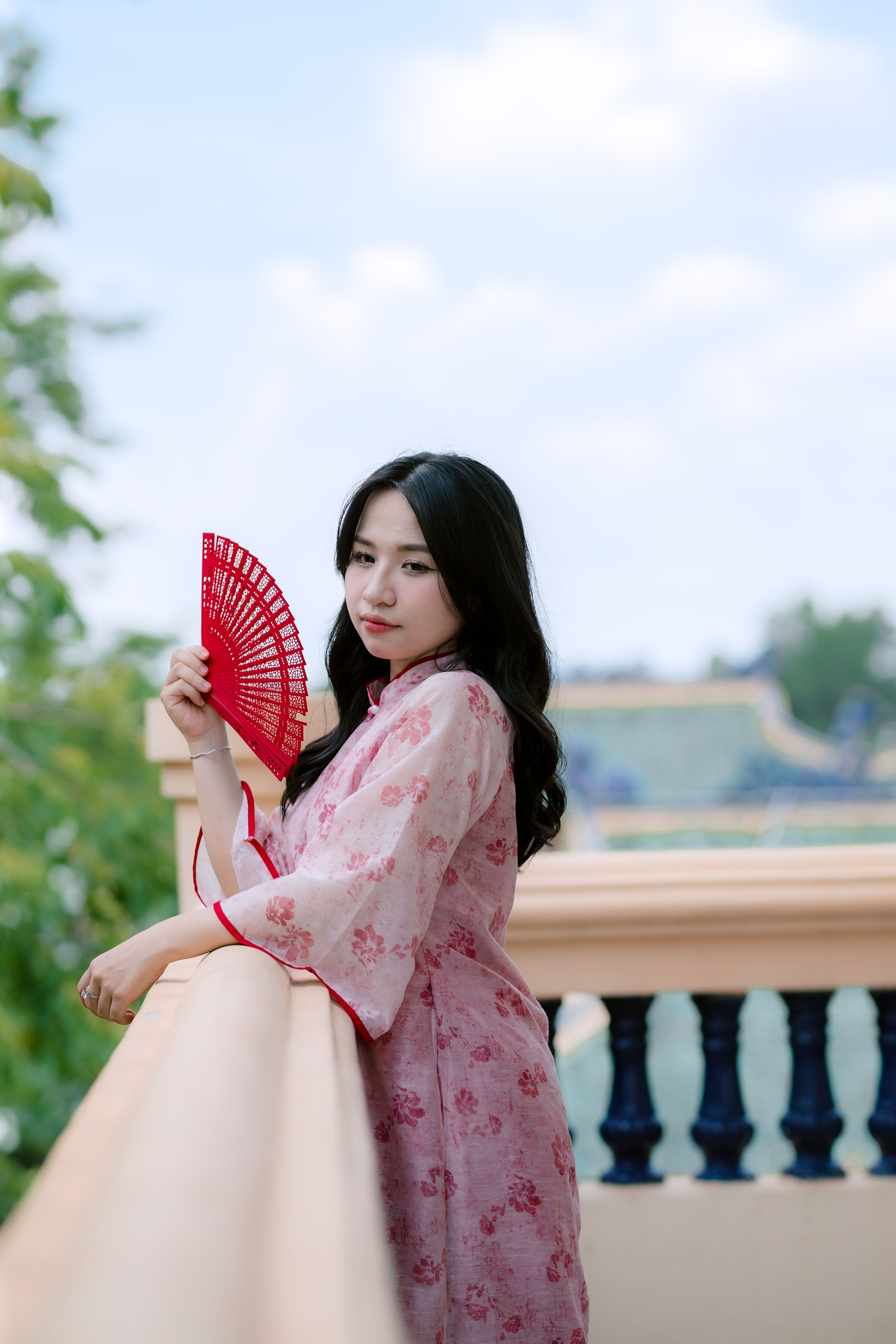 Woman in Traditional Dress Holding Red Fan Outdoors · Free Stock Photo