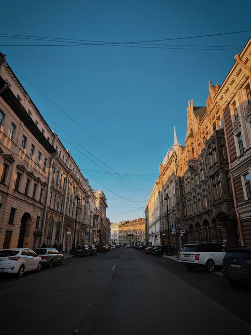 Free A serene view of a historic European street lined with classic architecture during sunset. Stock Photo