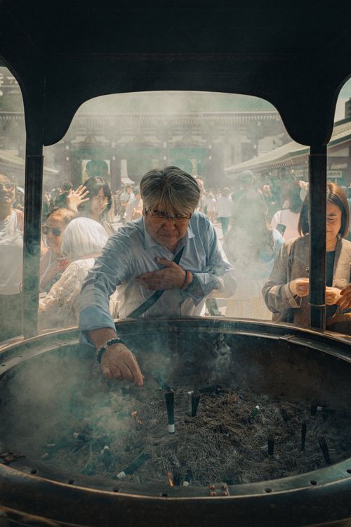 Free Man engaging in incense ritual at Senso-ji Temple, Tokyo. Stock Photo