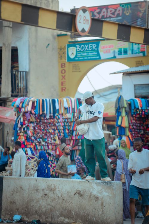 Free A busy market street with people shopping and vibrant textile displays. Stock Photo