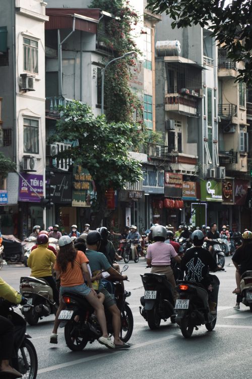 Free Motorcyclists and pedestrians in a lively Hanoi street, Vietnam. Stock Photo