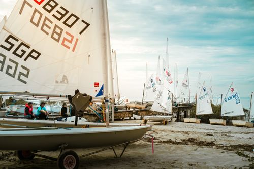 Free Sailboats neatly arranged on a sandy beach during the day, ideal for summer activities and sports enthusiasts. Stock Photo