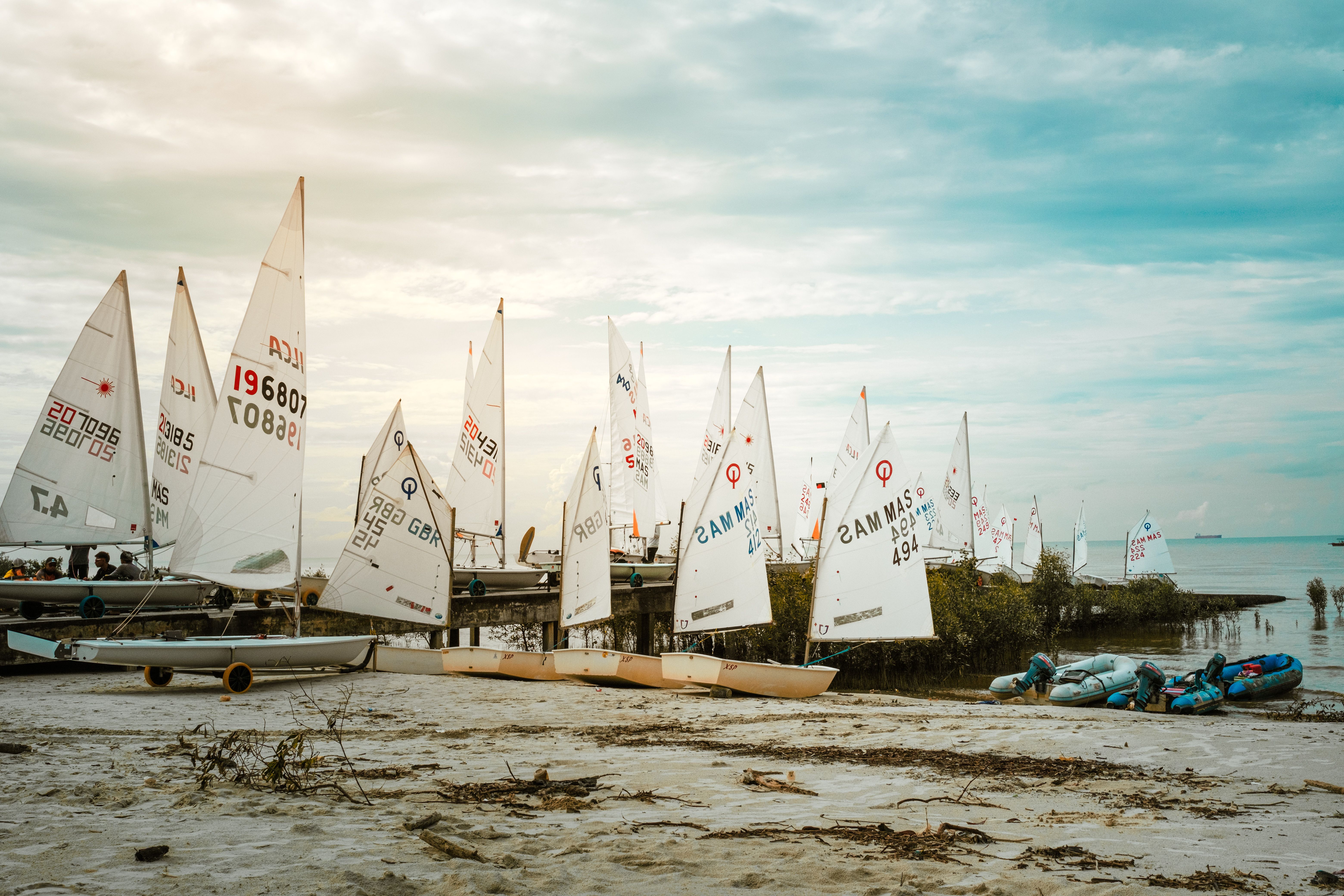 Scenic Beach with Sailboats on Sandy Shores · Free Stock Photo