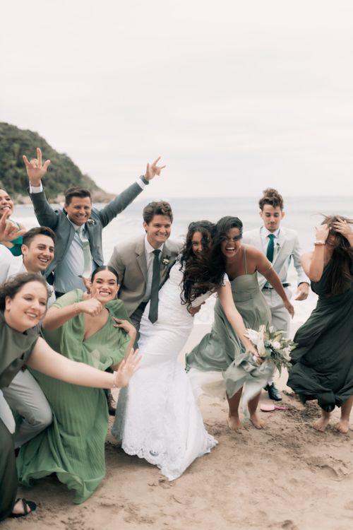 Free A vibrant bridal party celebrating on a picturesque beach. Stock Photo