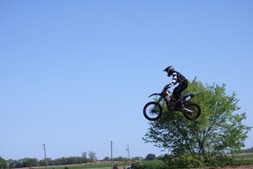 Free High-flying motocross action captured in Carroll, Ohio with a rider performing a jump against a clear blue sky. Stock Photo