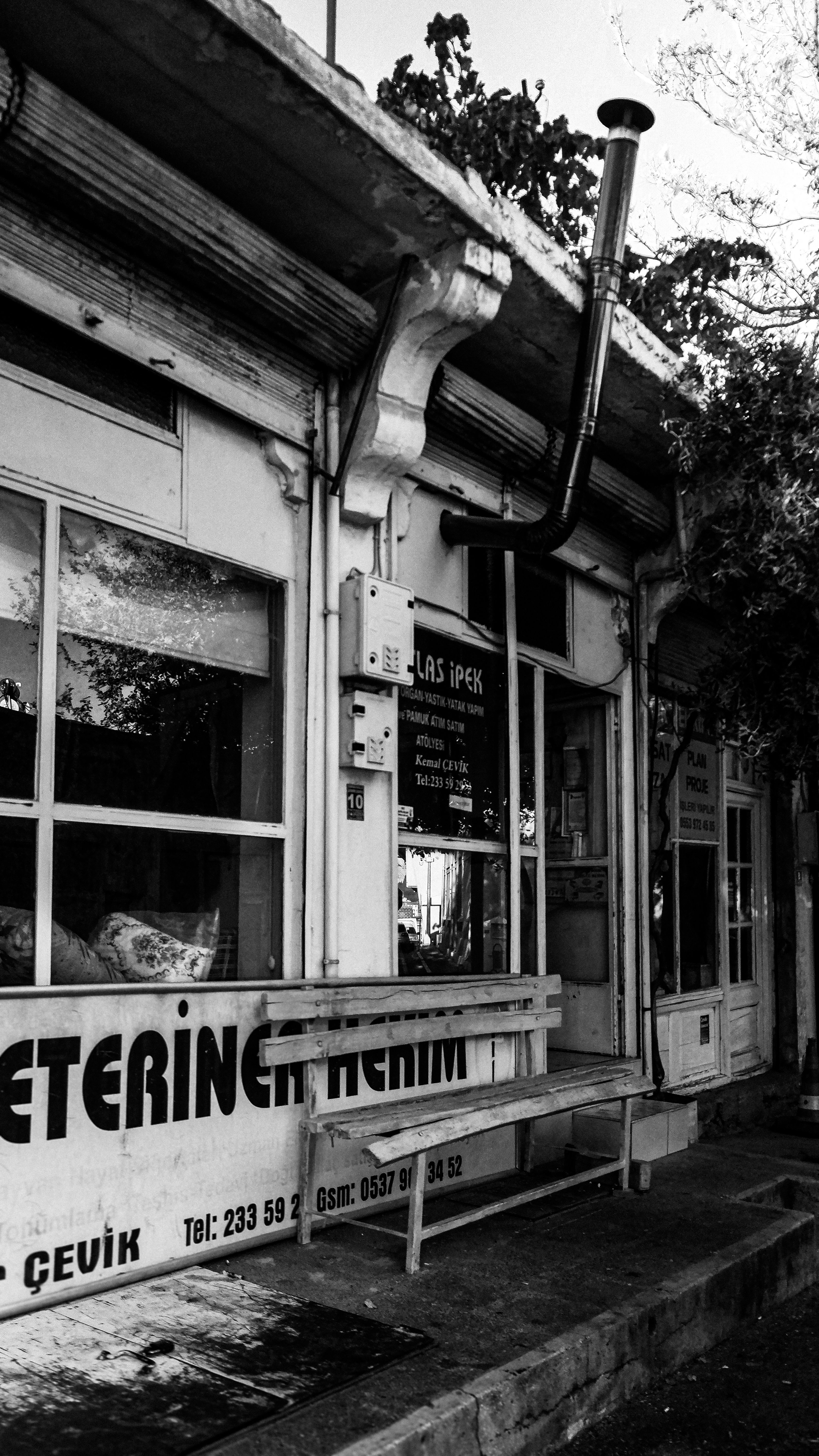 Black and white photo of a vintage shopfront in an urban setting. Moody atmosphere.