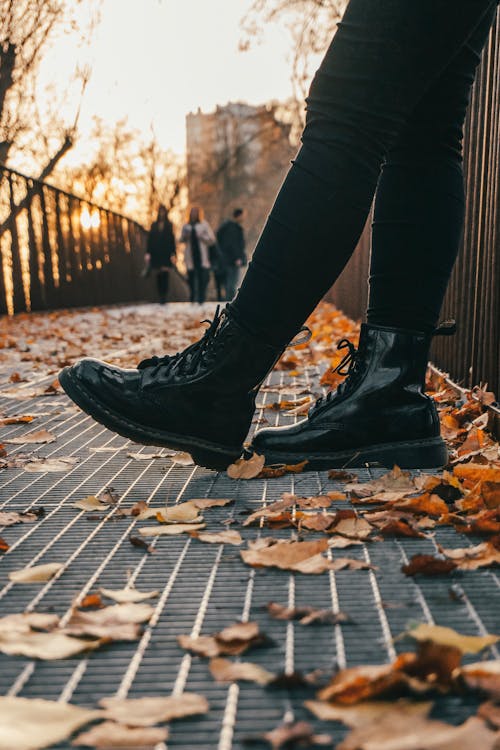 Low Angle Photo of Person Wearing Black Boots and Black Pants