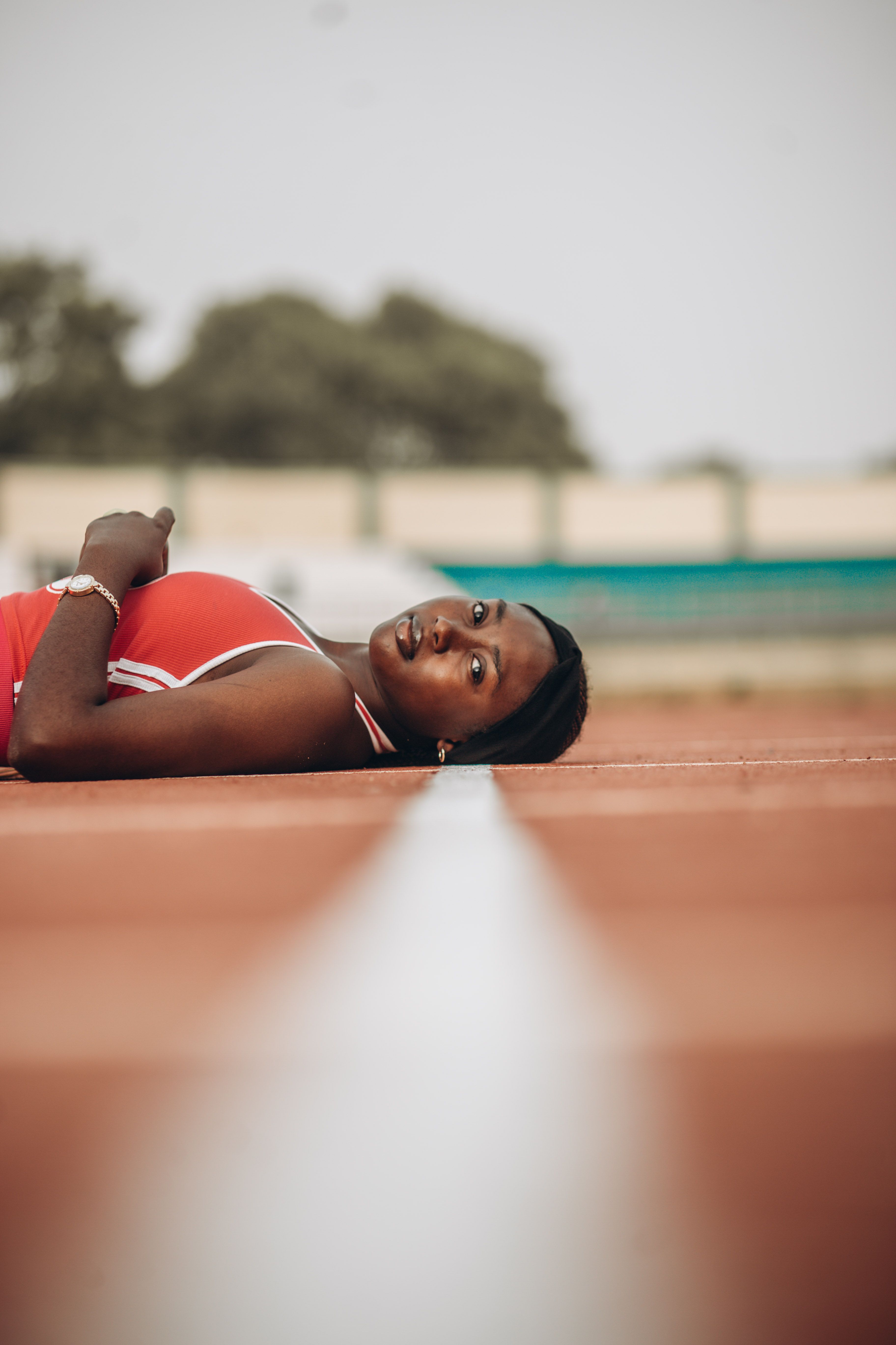 A focused athlete taking a break on a running track. Perfect for sports and fitness themes.