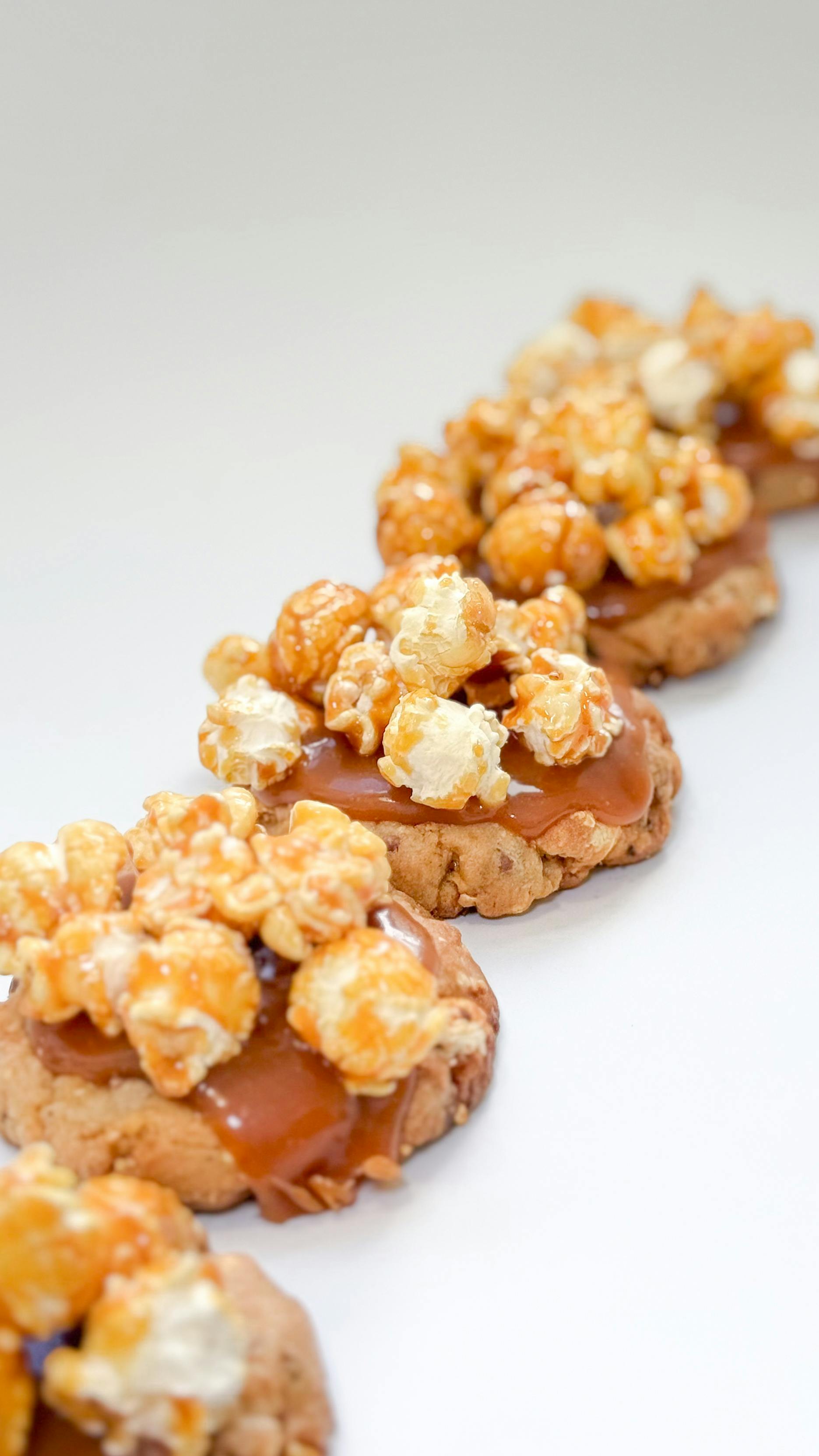 Gratuit Gros plan de biscuits garnis de pop-corn au caramel et arrosés de caramel, idéal pour les amateurs de desserts. Photos