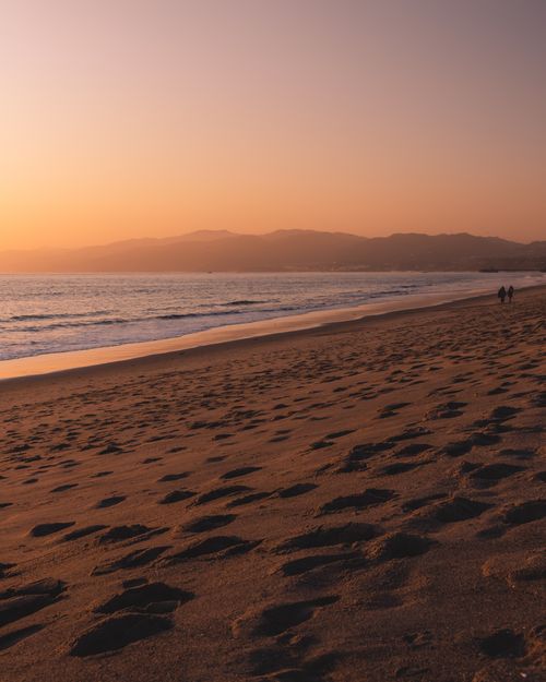 Free A serene sunset over a sandy beach, perfect for relaxation. Stock Photo
