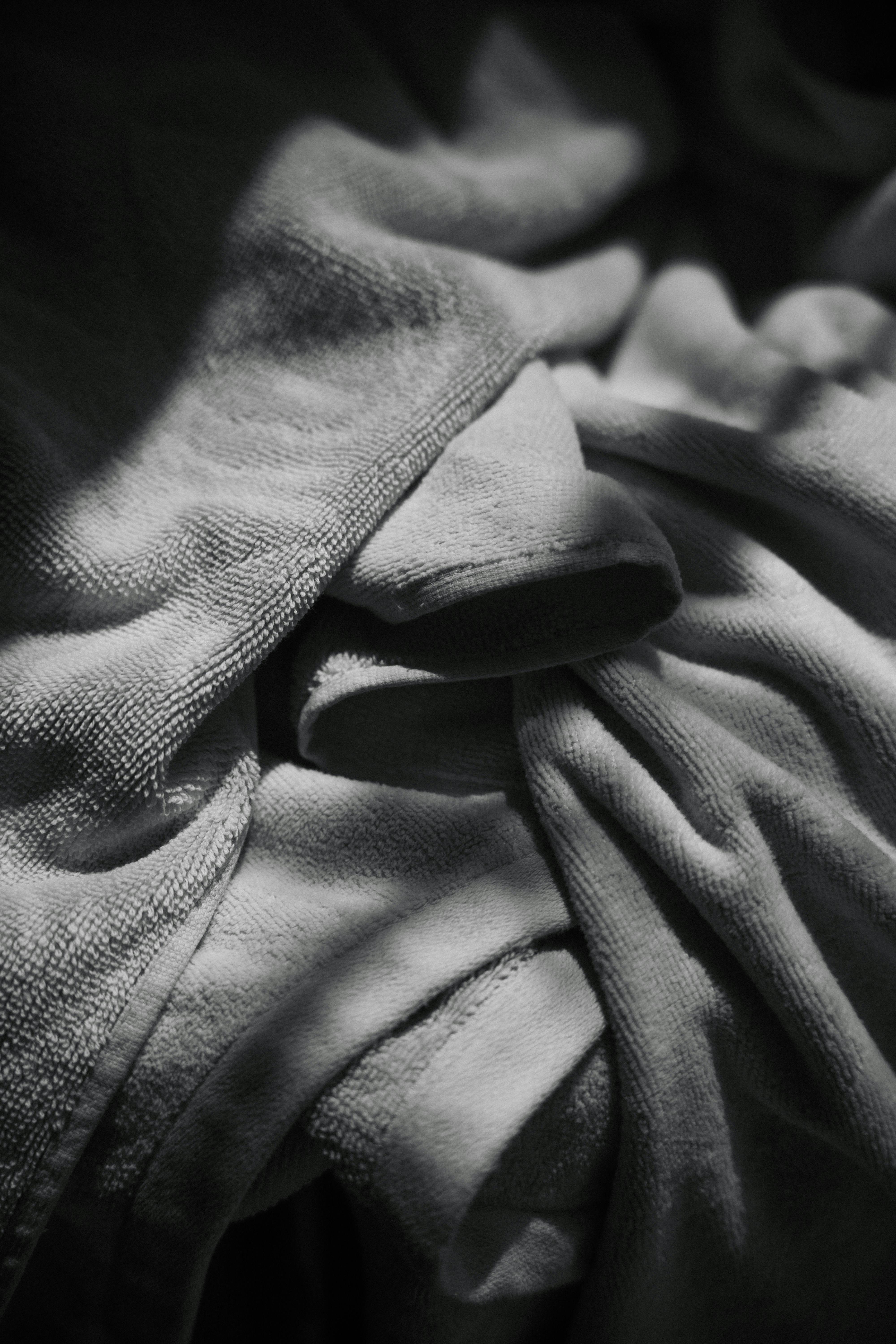 ingyenes Absztrakt fekete-fehér fotó, amely texturált törölközőket ábrázol drámai megvilágítással és árnyékokkal. Stockfotó