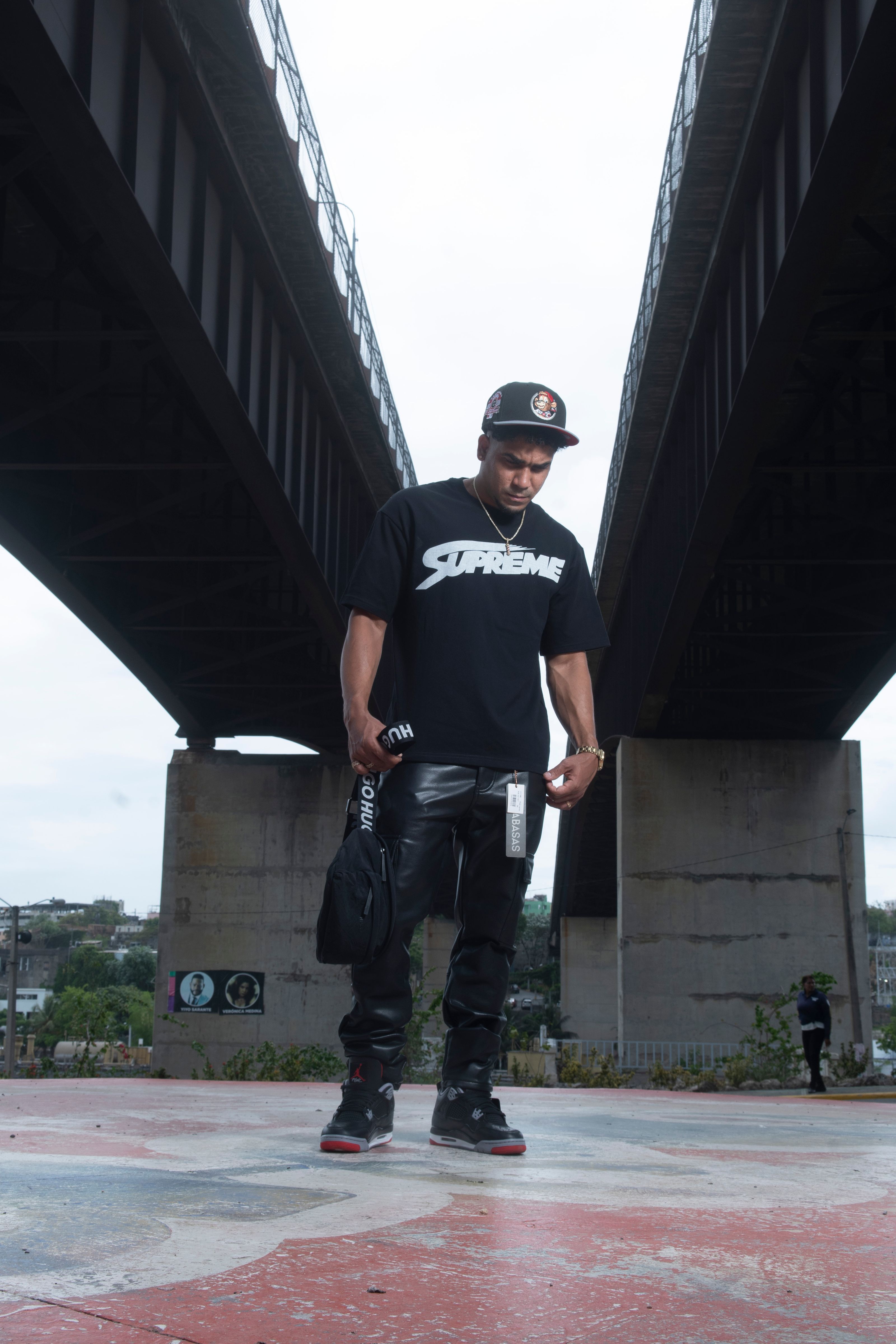 Jovem adulta em estilo streetwear posando sob uma ponte urbana. Estilo moderno, ângulo dinâmico.