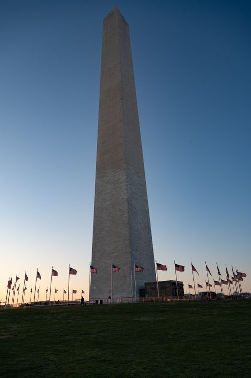 Free The Washington Monument against a sunset sky with American flags waving below. Stock Photo