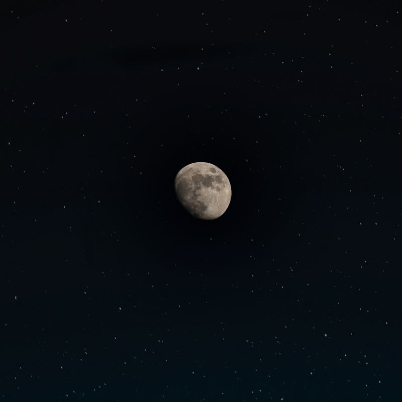 Waning moon in a star-flecked night sky — photo by William Hadley on Pexels