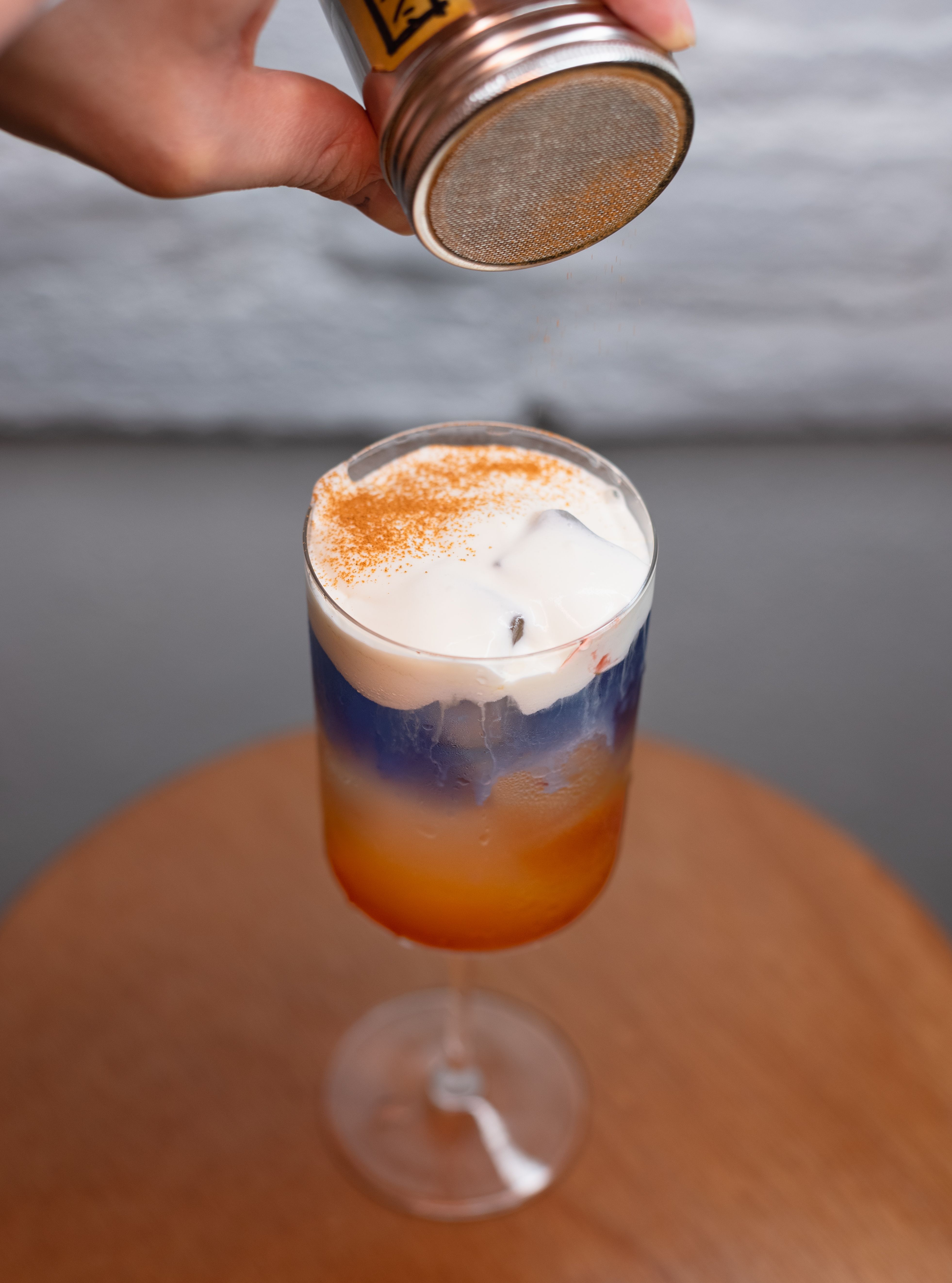 Vibrant layered iced coffee with a sprinkle of spices in a cozy Shinjuku café.