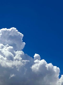 Blue sky with fluffy white clouds, perfect for serene outdoor settings or atmosphere themes.
